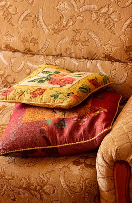 A vintage-style white wooden sofa with curved legs and armrests, situated in a bright, minimalistic room with white walls and a glossy white floor. Draped over the sofa is a soft beige blanket, and na